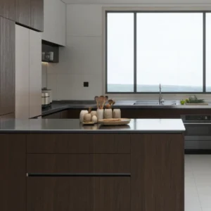 Island view into U-shaped kitchen—charcoal base cabinets, large window, built-in oven and long worktop