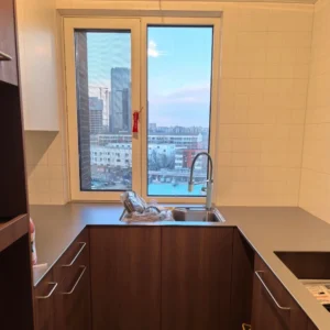 Modern apartment kitchen with 5mm stainless steel countertop and walnut cabinets