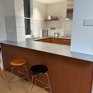 Japandi style kitchen with stainless steel island and warm wood cabinets