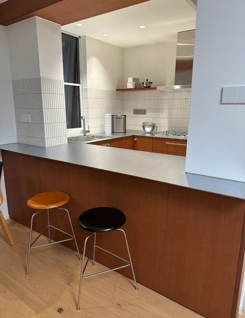 Japandi style kitchen with stainless steel island and warm wood cabinets